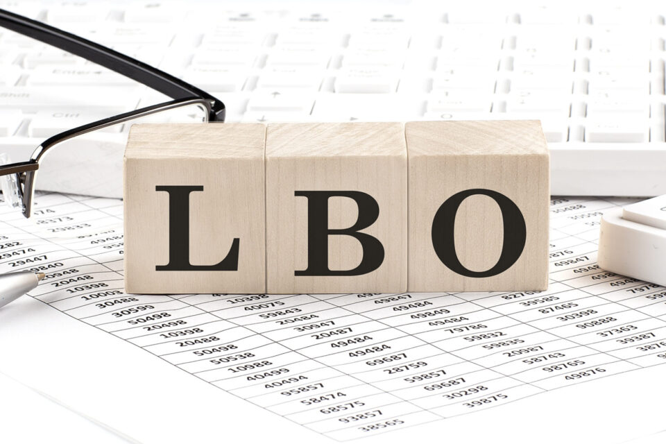 LBO written on wooden cube with keyboard , calculator, chart,glasses.Business
